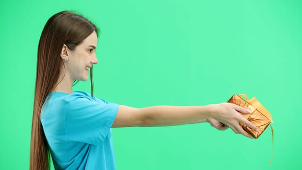 Woman, close-up, on a green background, with a gift.