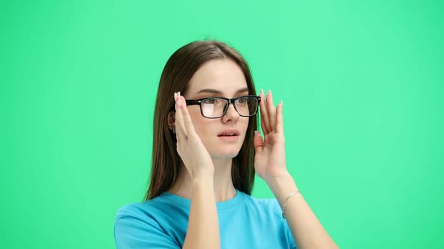 Woman, close-up, on a green background, wearing glasses.