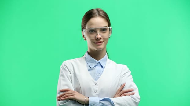 A female doctor, close-up, on a green background, crossed her arms.