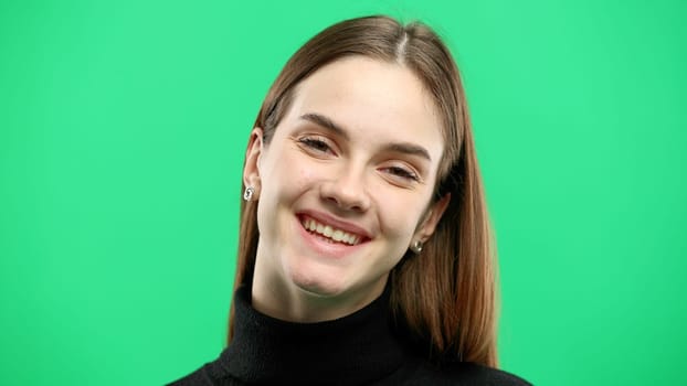 Woman's face, close-up, on a green background.