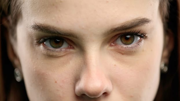 Woman's face, close-up, on a green background.