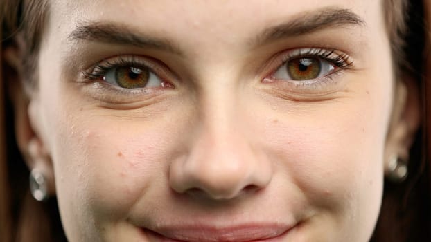 Woman's face, close-up, on a green background.