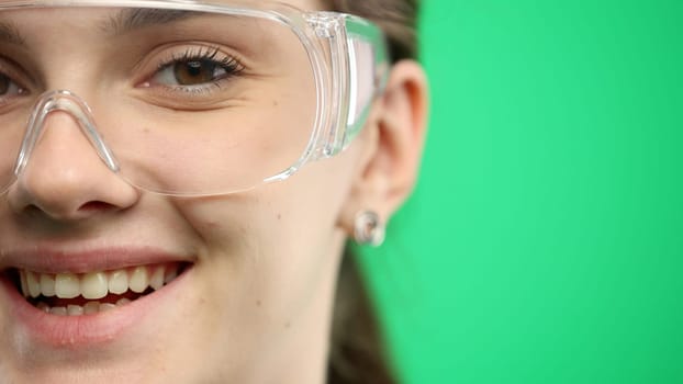 Woman's face, close-up, on a green background.