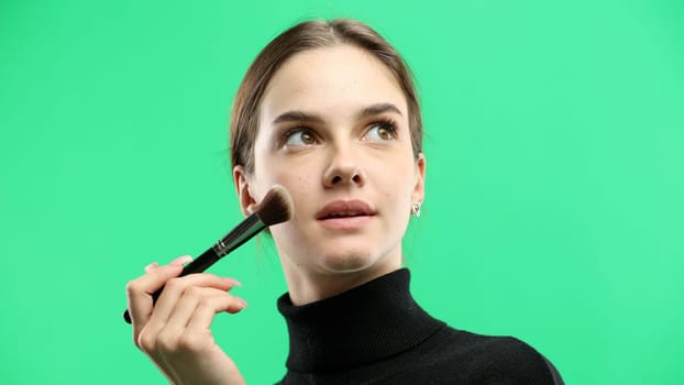 Woman's face, close-up, on a green background.