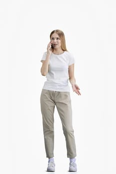 A woman, full-length, on a white background, talking on the phone.