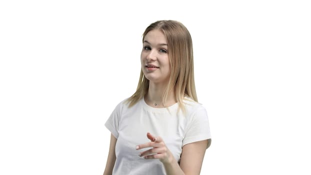 A woman, close-up, on a white background, points forward.