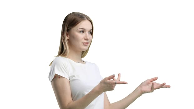 A woman, close-up, on a white background, points to the side.