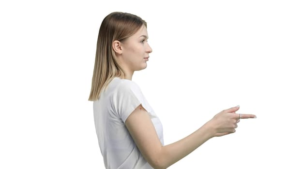 A woman, close-up, on a white background, points to the side.