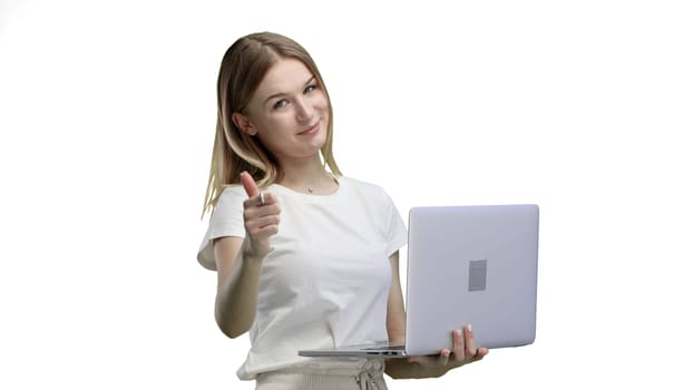 A woman, close-up, on a white background, uses a laptop.