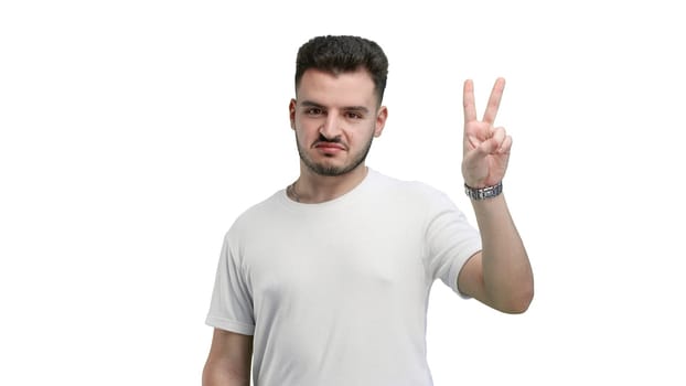 A man, close-up, on a white background, shows a victory sign.