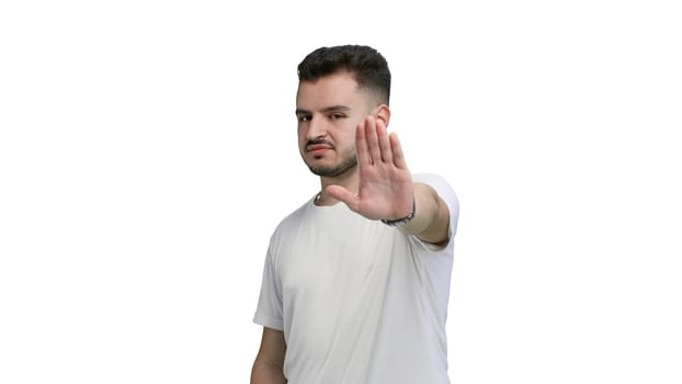 A man, close-up, on a white background, shows a stop sign.