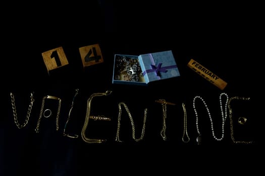 valentine's day concept with valentine written with gold jewelry