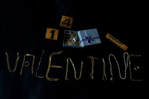 valentine's day concept with valentine written with gold jewelry