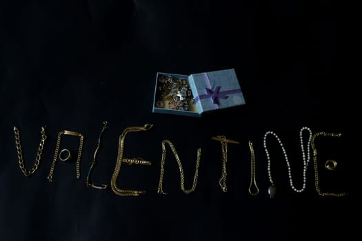 valentine's day concept with valentine written with gold jewelry