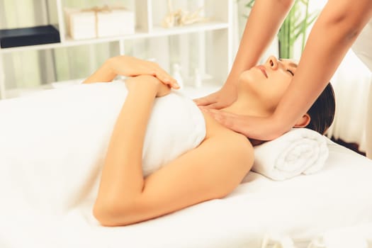 Caucasian woman customer enjoying relaxing anti-stress spa massage and pampering with beauty skin recreation leisure in day light ambient salon spa at luxury resort or hotel. Quiescent