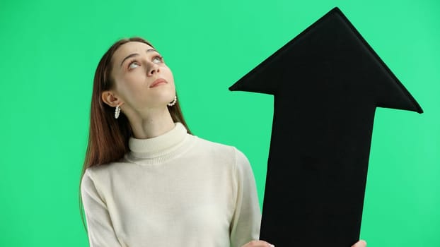 Woman, close-up, on a green background, pointing up arrow.