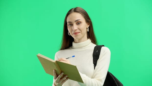 Woman, close-up, on a green background, with a backpack.