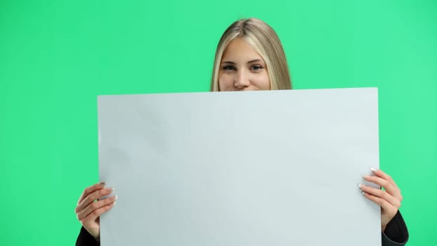 A woman, close-up, on a green background, shows a white sheet.