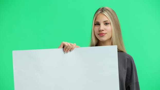 A woman, close-up, on a green background, shows a white sheet.