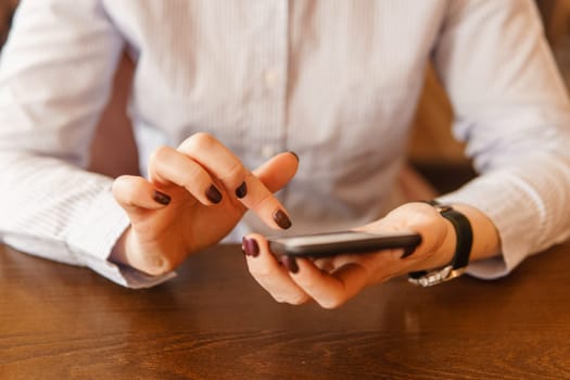 Mobile phone in female hands. Beautiful women's manicure