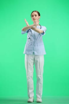 A full-length female doctor, on a green background, shows a pause sign.