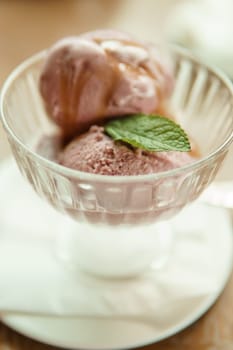 Closeup of cherry granita in glass bowl, on color wooden background