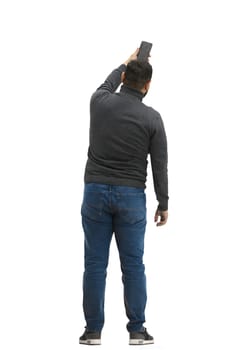 A man, full-length, on a white background, waving his phone.