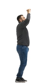 A man, full-length, on a white background, raised his hands up.