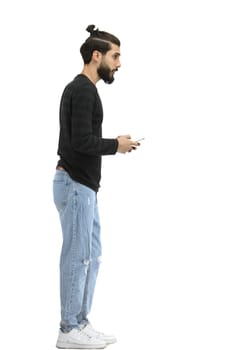 A man, full-length, on a white background, with phone.