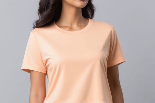 Woman in peach fuzz colored tshirt, can be used for design, mock up. The trending color of 2024