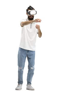 Man, full-length, on a white background, wearing VR glasses.