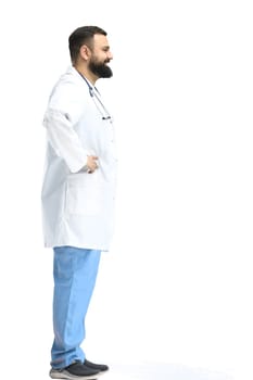 Male doctor, full-length, on a white background, hands on hips.