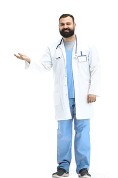 The male doctor, full-length, on a white background, points to the side.
