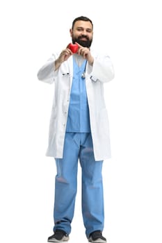 Male doctor, full-length, on a white background, shows a heart.