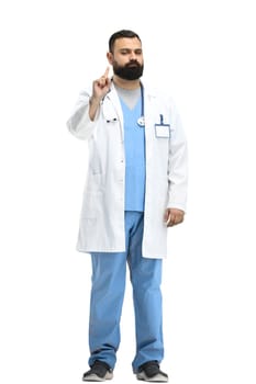 The male doctor, in full height, on a white background, shows an important sign.