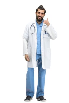 A male doctor, full-length, on a white background, shows a call sign.
