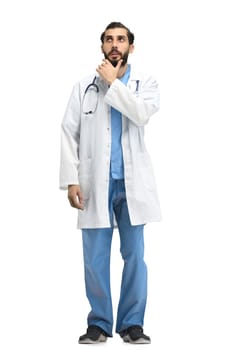 The male doctor, full-length, on a white background, thinks.