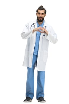 Male doctor, full-length, on a white background, shows a heart.