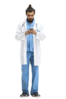 Male doctor, full-length, on a white background, with a phone.