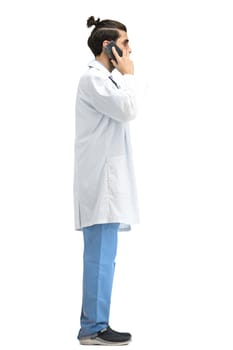 Male doctor, full-length, on a white background, with a phone.