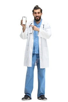 Male doctor, full-length, on a white background, with a phone.