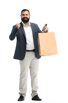 A man, full-length, on a white background, with bags and a phone.