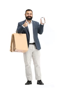 A man, full-length, on a white background, with bags and a phone.