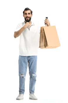 A man, full-length, on a white background, with bags and a phone.