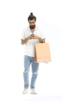 A man, full-length, on a white background, with bags and a phone.