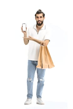 A man, full-length, on a white background, with bags and a phone.