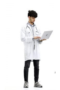 Male doctor, full-length, on a white background, with a laptop.