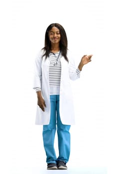 A female doctor, on a white background, in full height, points to the side.