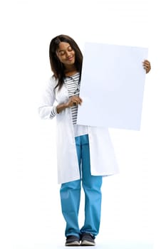 A female doctor, on a white background, in full height, shows a white sheet.