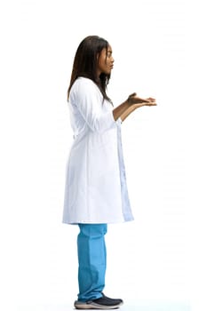A woman doctor, full-length, on a white background, spreads her arms.